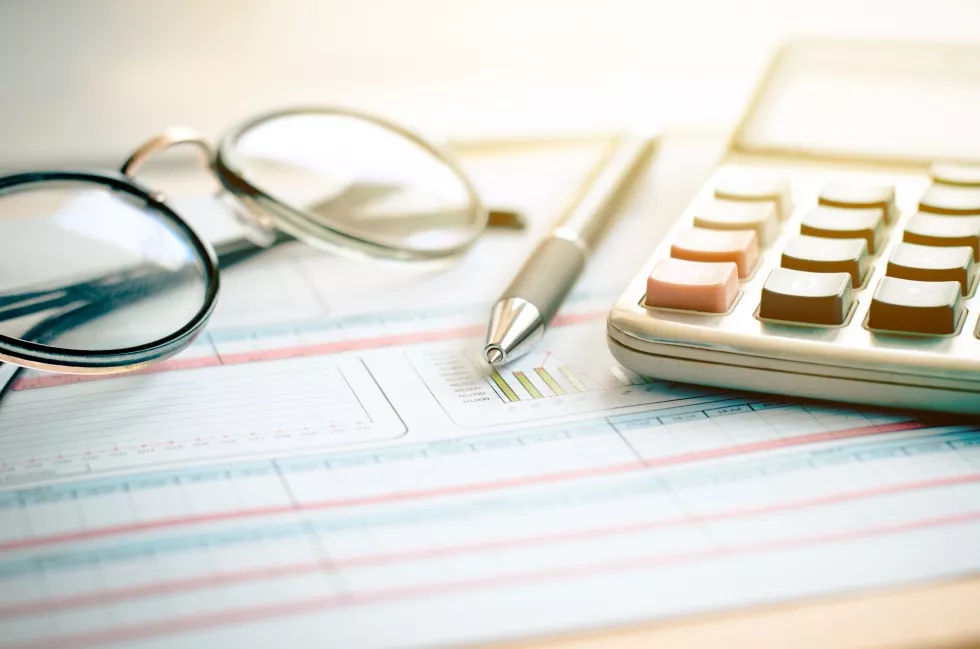 close-up-eyeglasses-with-pen-calculator-document