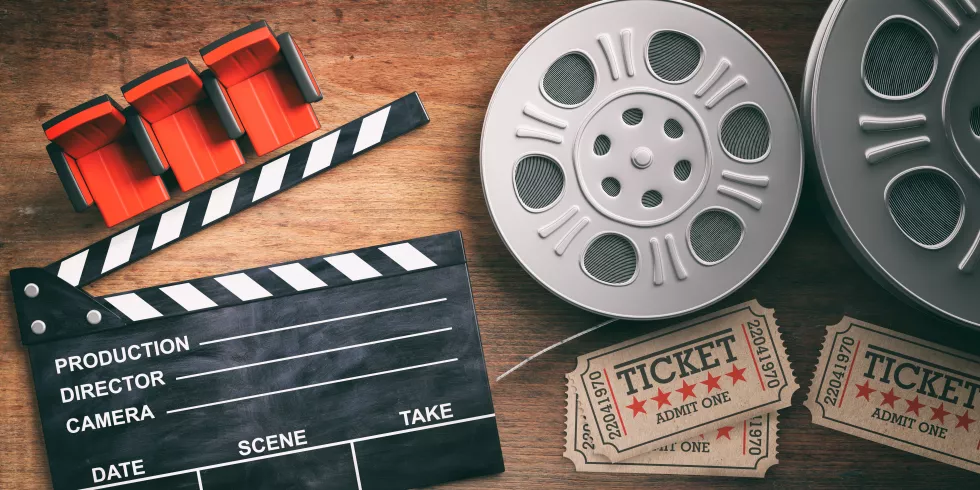 film-reels-with-retro-cinema-tickets-movie-clapper-red-theater-seats-wooden-background-3d-illustration