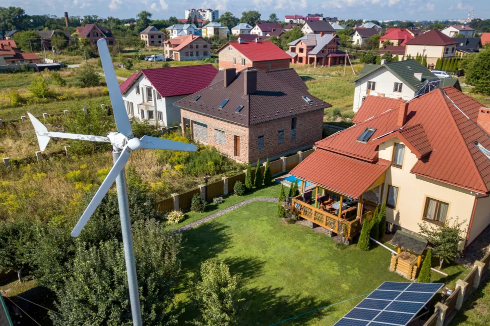 aerial-view-new-autonomous-house-with-solar-panels-water-heating-radiators-roof-wind-powered-turbine-green-yard