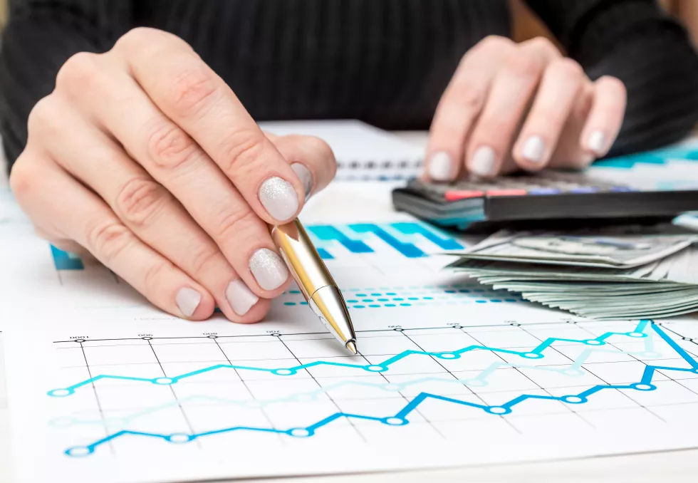 businesswoman-pointing-business-graphs-by-pen-workplace-close-up-business-concept