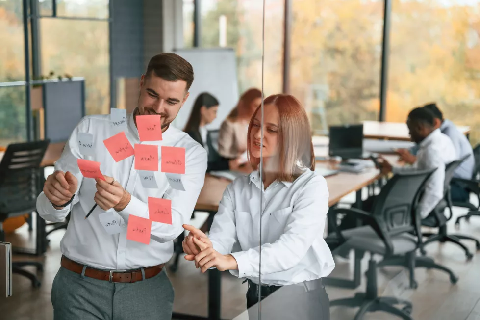two-people-are-putting-stickers-glass-planning-project-group-office-workers-are-together-indoors