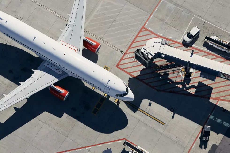 aerial-view-plane-airplane-front-passenger-boarding-bridge-from-airport-terminal