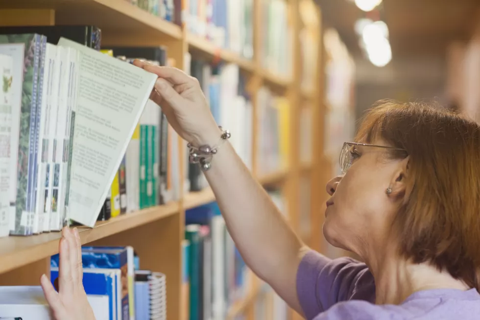 mature-female-librarian-searching-book