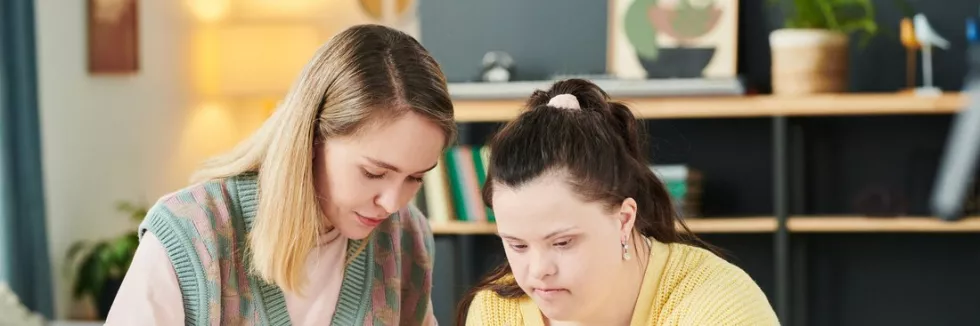 Edukacja-i-rehabilitacja-osob-z-niepelnosprawnoscia-test-pedagozka-prowadzi-zajecia-plastyczne-z-mloda-kobieta-z-zespolem-downa