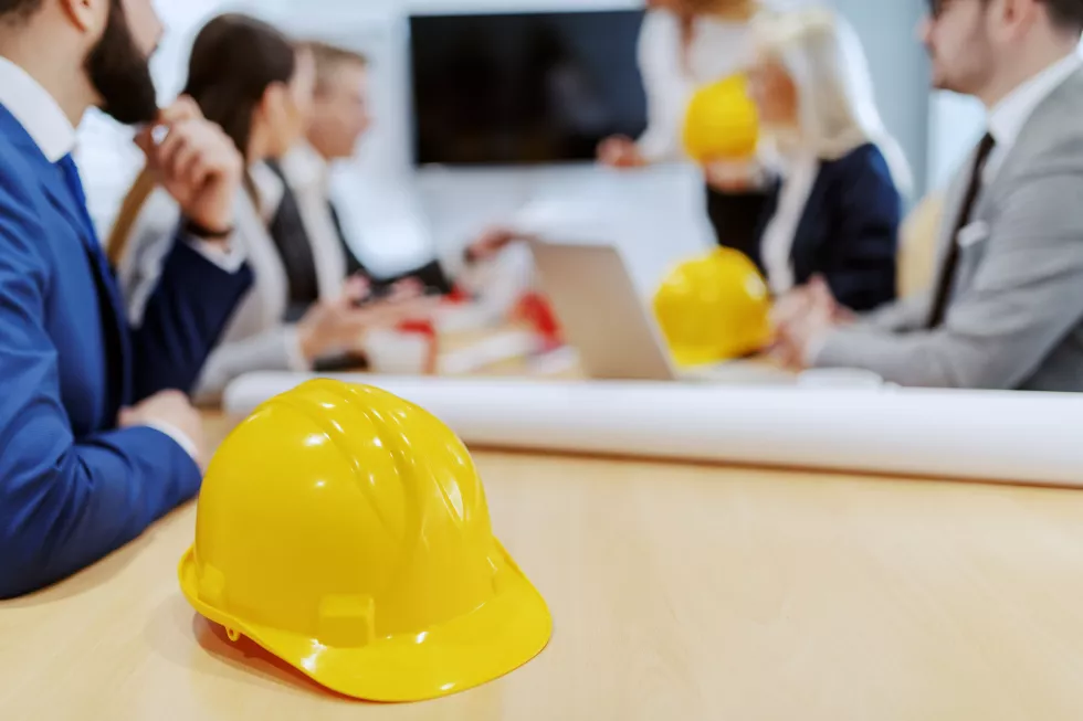 architects-having-meeting-boardroom-selective-focus-yellow-helmet