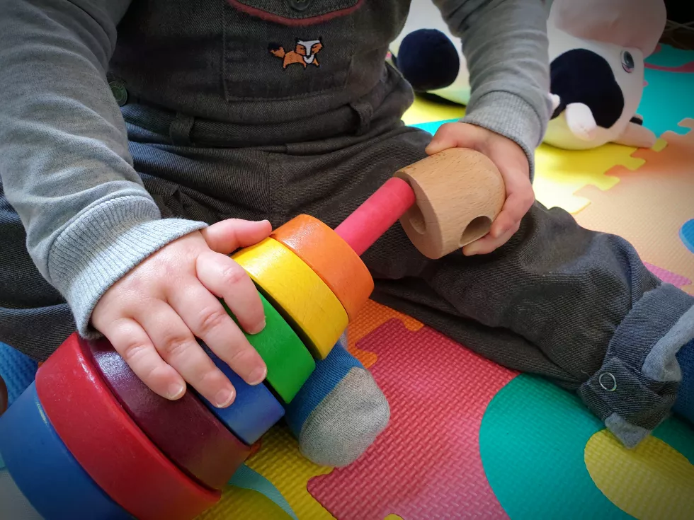 midsection-boy-playing-with-multi-colored-toys-while-sitting-floor