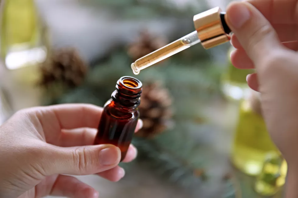 woman-filling-bottle-with-pine-essential-oil
