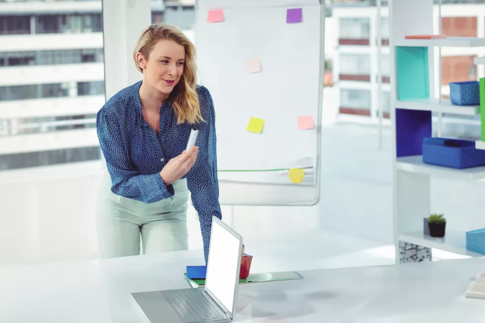 office-redhead-businesswoman-presenting-ideas-using-laptop-colleagues-copy-space