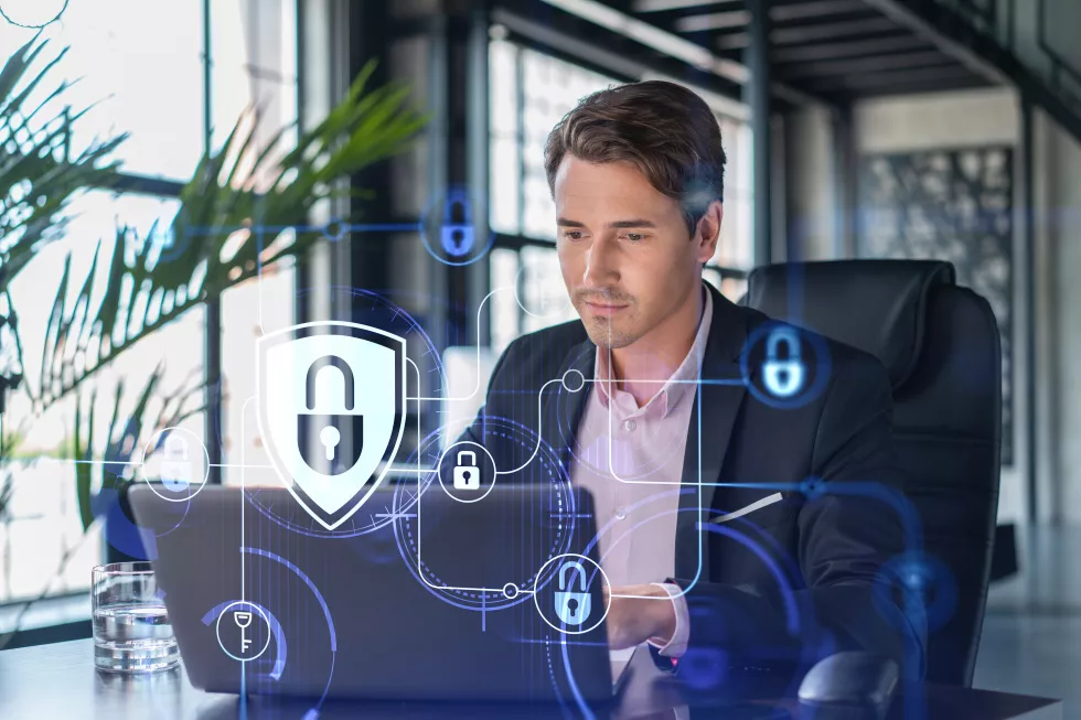 handsome-businessman-suit-workplace-working-with-laptop-defend-customer-cyber-security-concept-clients-information-protection-brainstorm-padlock-hologram-office-background