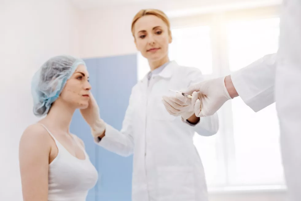 nice-pleasant-female-doctor-wearing-disposable-gloves-taking-syringe-while-doing-botox-injections