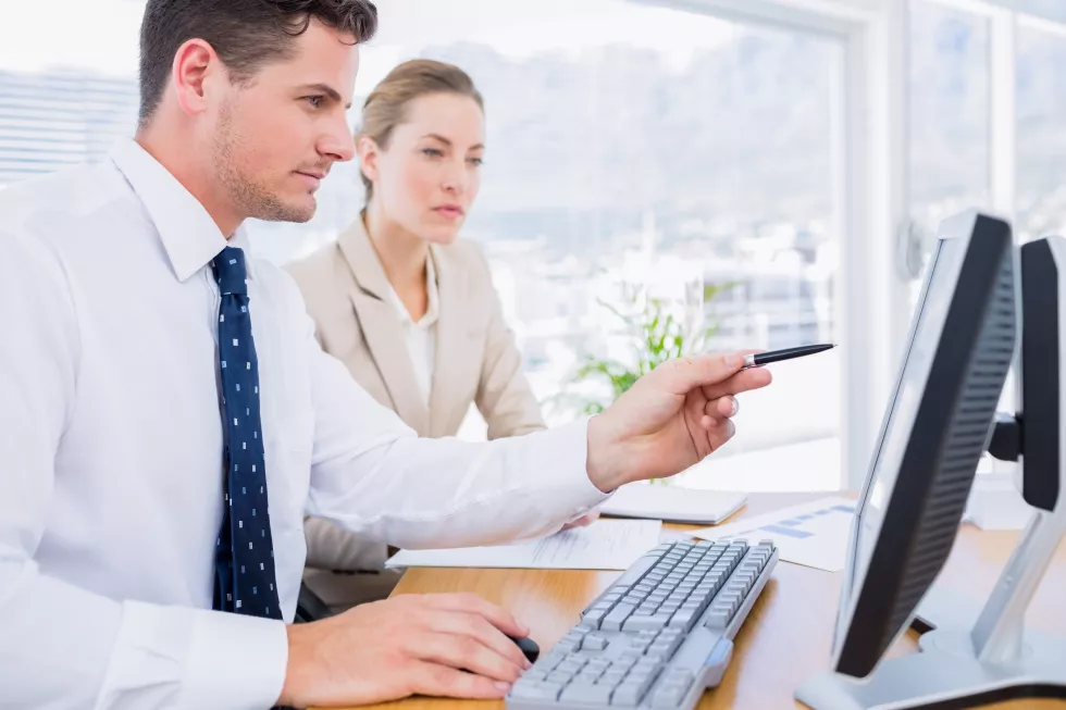 smartly-dressed-colleagues-using-computer
