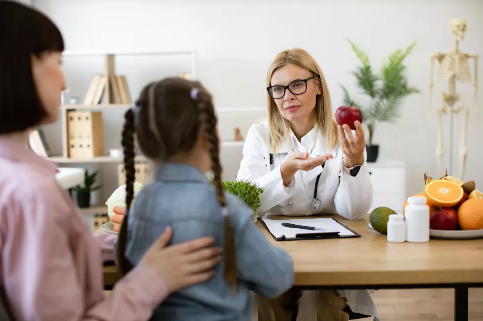 mature-woman-with-apple-chatting-with-little-female-child-her-mother