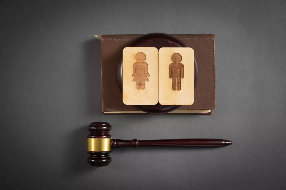 judge-gavel-with-male-female-wooden-symbols-black-background
