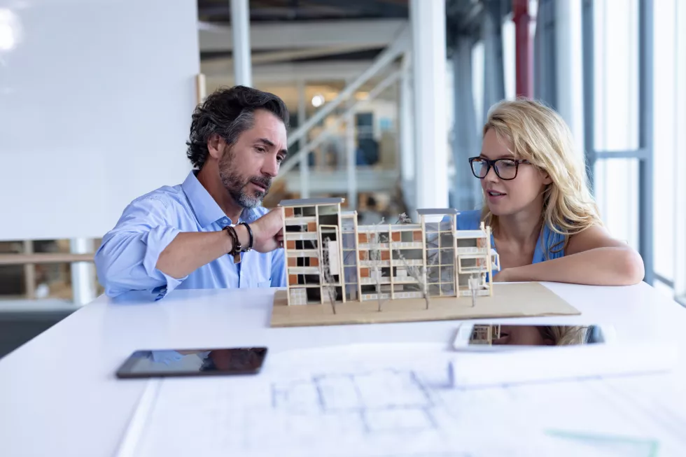 male-female-architect-discussing-architectural-model-table-modern-office