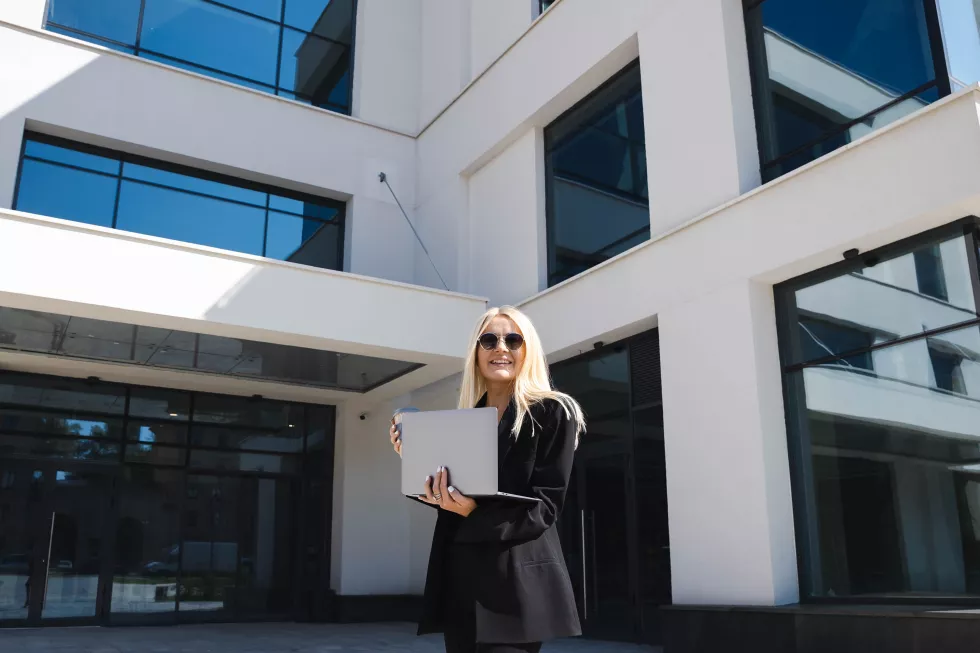 young-woman-stylish-suit-with-laptop-cup-coffee-background-business-center