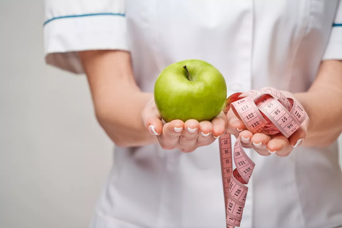 nutritionist-doctor-healthy-lifestyle-concept-holding-organic-fresh-green-apple-measure-tape