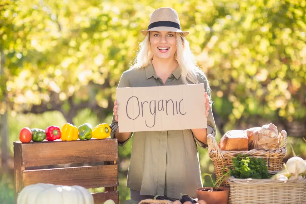 smiling-blonde-holding-organic-signboard