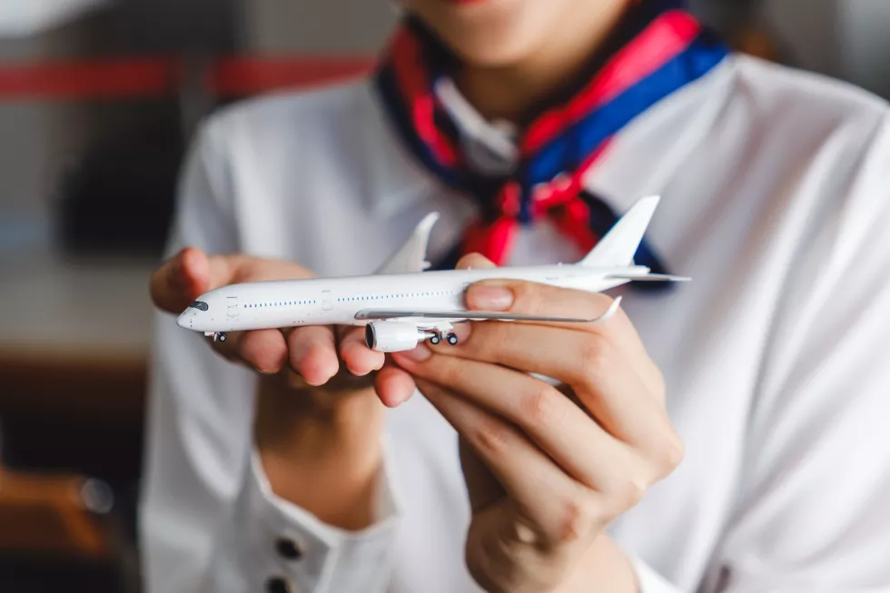 closeup-airline-staff-holding-model-airplane-hands-concept-aviation-service-flight-planning