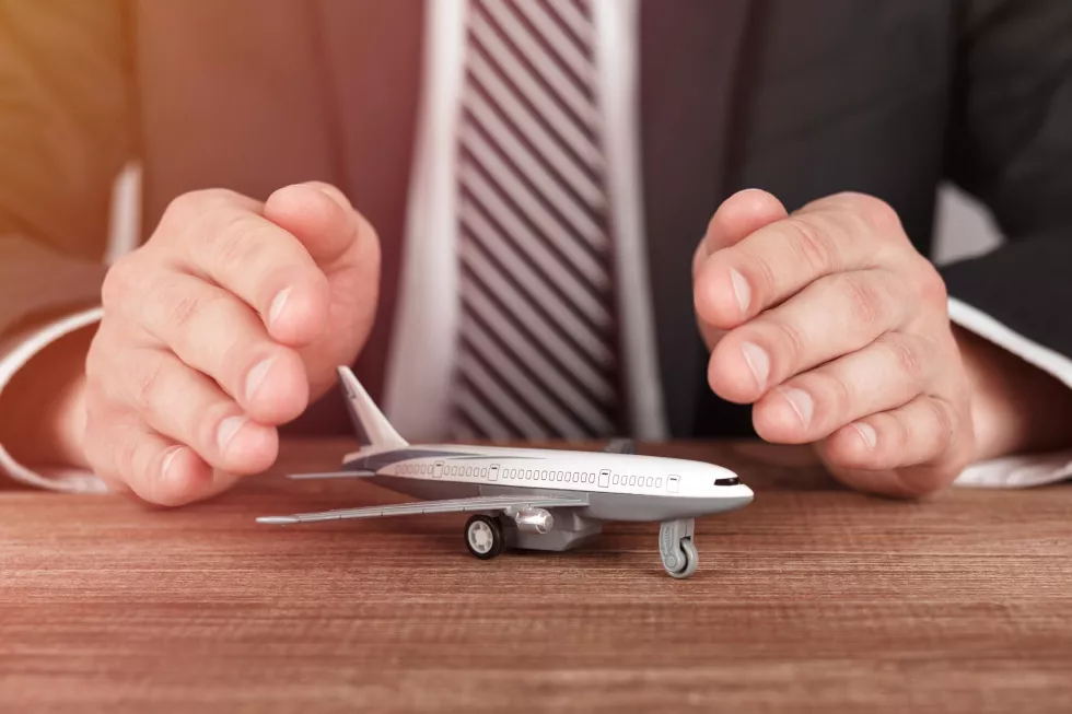 airplane-model-surrounded-by-hands-gesture-protection-concept-airline-safety-security-insurance