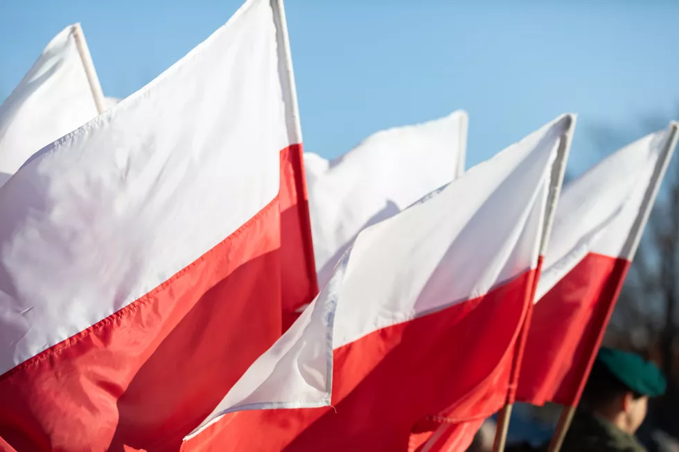 polish-flags-are-flying-background-stands-soldier-uniform-green-beret