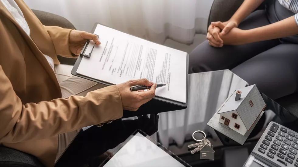 midsection-woman-holding-paper-while-sitting-table