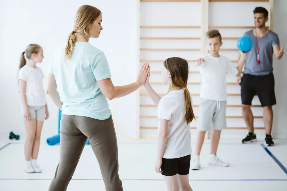 girl-doing-high-five-with-her-teacher-physical-education-school
