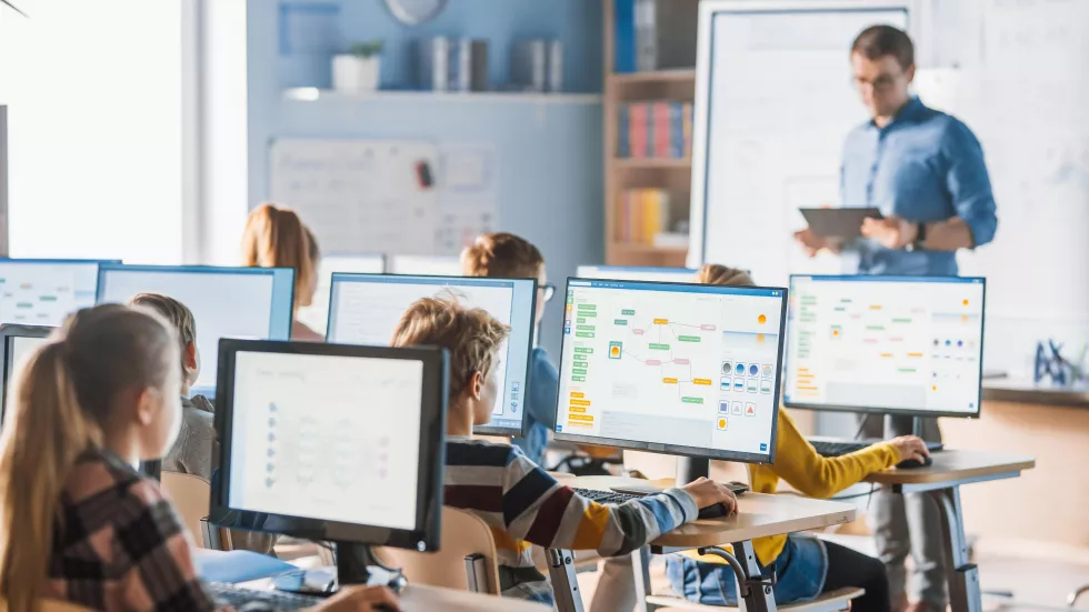 teacher-stands-front-computer-screen-with-teacher-front-him