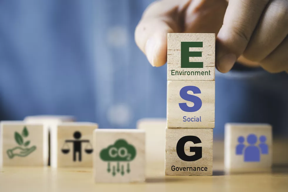 businessman-assemble-esg-wording-wooden-cube-block-sustainable-organization-development-corporation-environment-social-governance-concept
