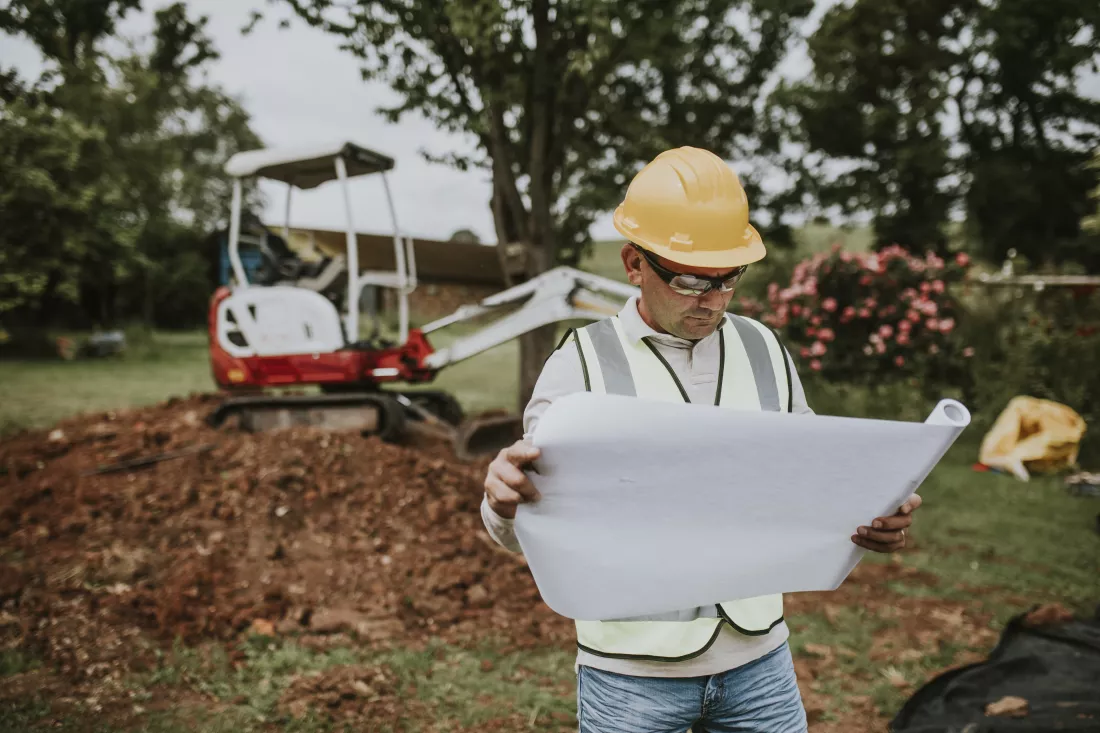middle-aged-contractor-reading-floor-plan-site