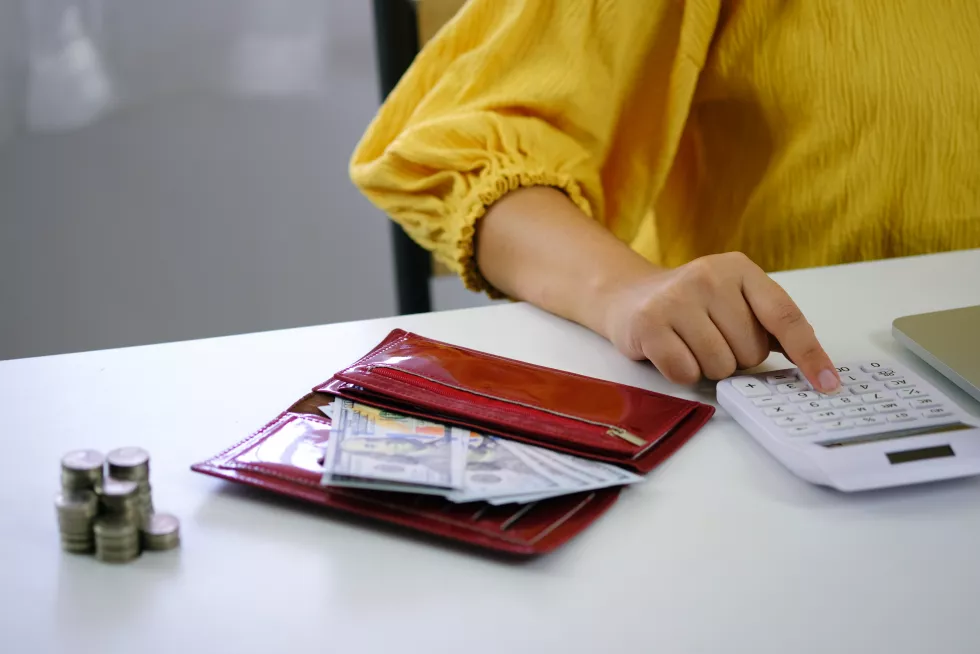 midsection-woman-using-calculator-table