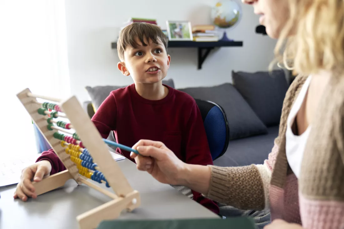 boy-is-curious-while-homeschooling-mom-teaches-using-abacus