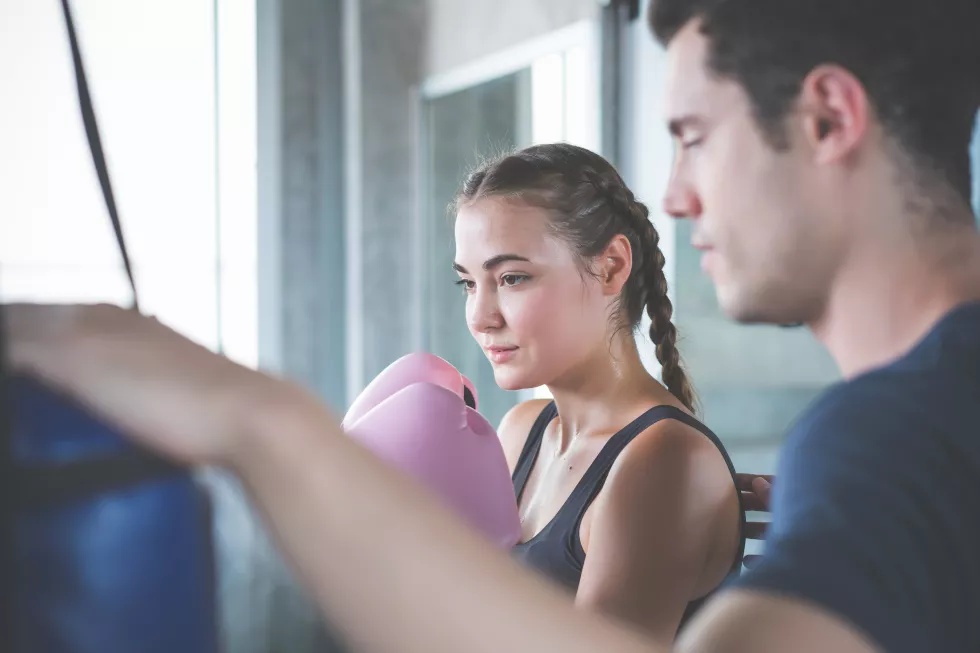 coach-standing-by-woman-boxing-club